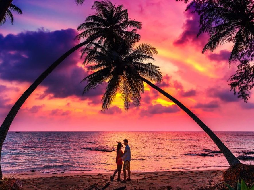 Honeymoon couple silhouette on a sunset beach
